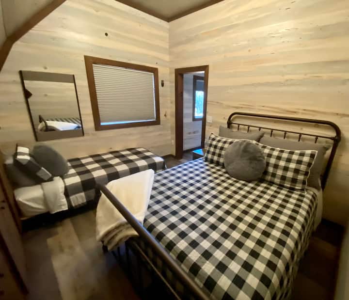 חדר שינה לאורחים עם מיטת קווין סייז ומיטת יחיד.