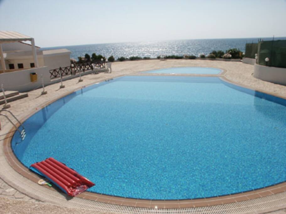 Communal pool and nearby sea in background