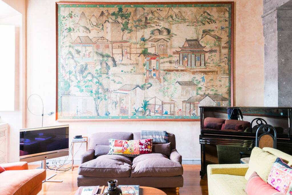 Living room with 4 sofa, piano, cable tv.
