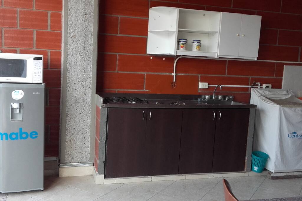 cocina con estufa, nevera y horno microondas