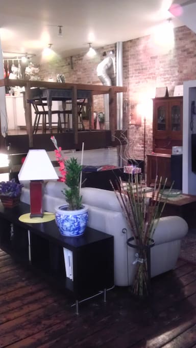 Comfy leather couch and big screen TV on the loft's main level, kitchen on upper level.