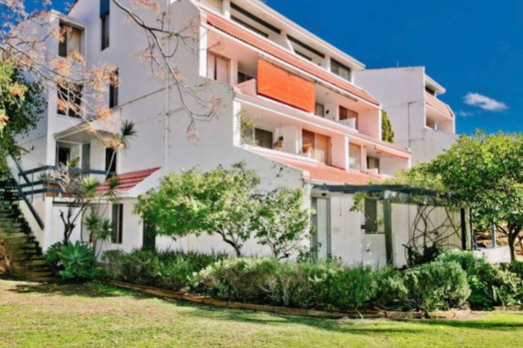 The unit is the lower ground level with the garden bed/tree surrounding it.