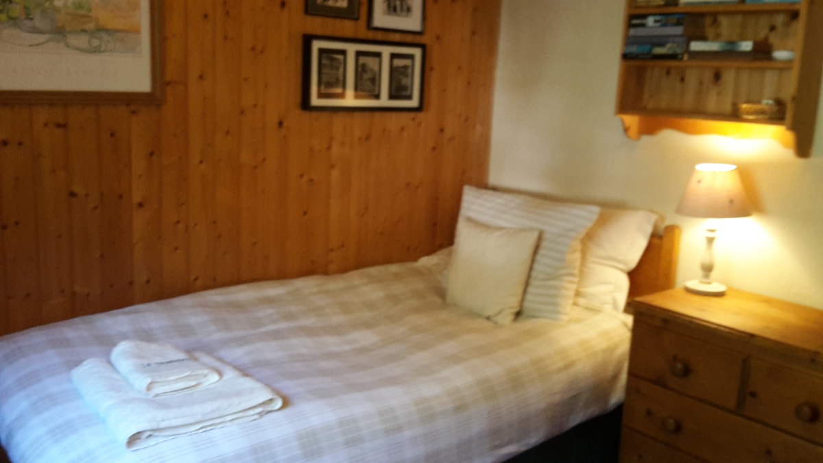 Jednostruka spavaća soba u kojoj se nalazi i ormar, komoda s ladicama i umivaonik