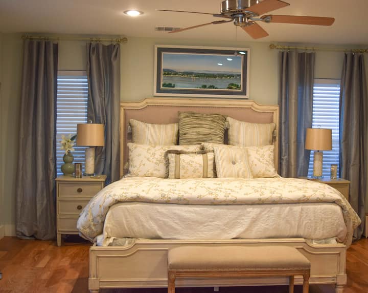 主卧-加大双人床，配有电视、书架和椅子可供阅读。 