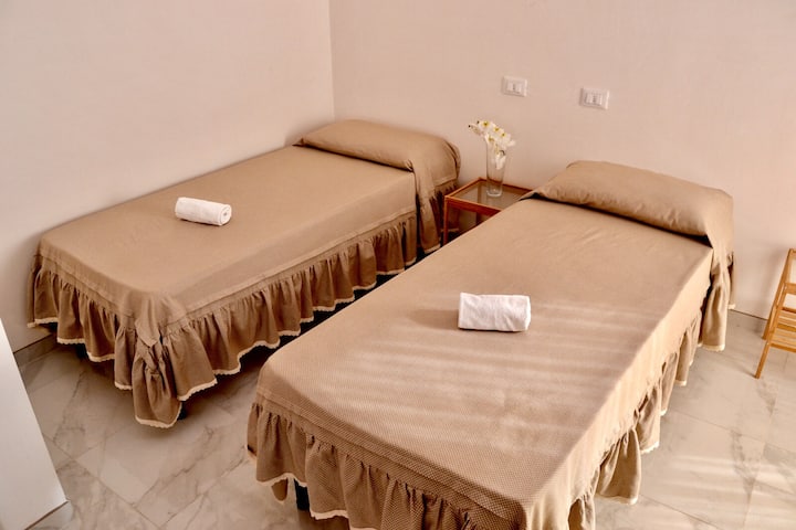 one bedroom with two single beds and bathroom inside 