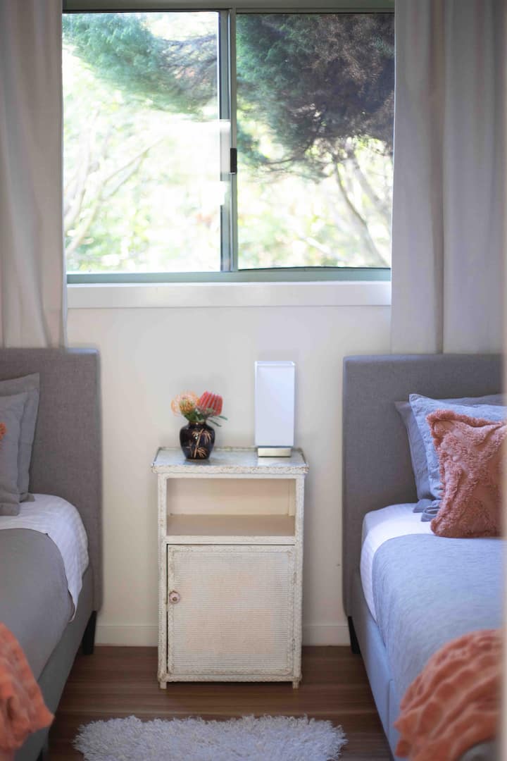 The second bedroom has two single beds with lovely linen included. All bedrooms look out to the garden. 