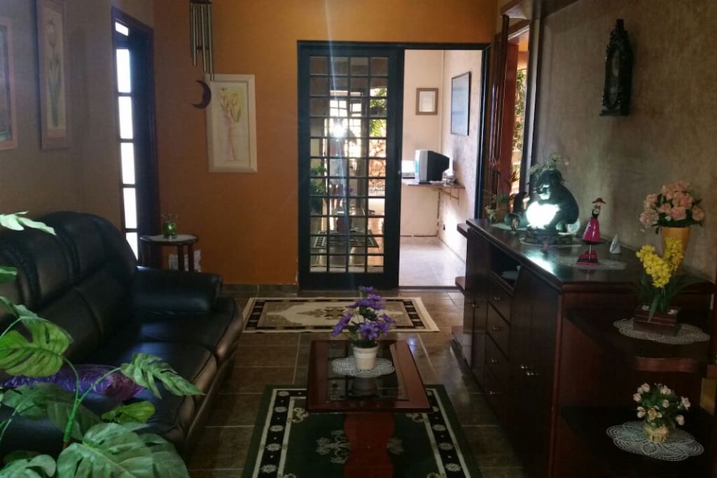 Sala de estar e escritório ao fundo.