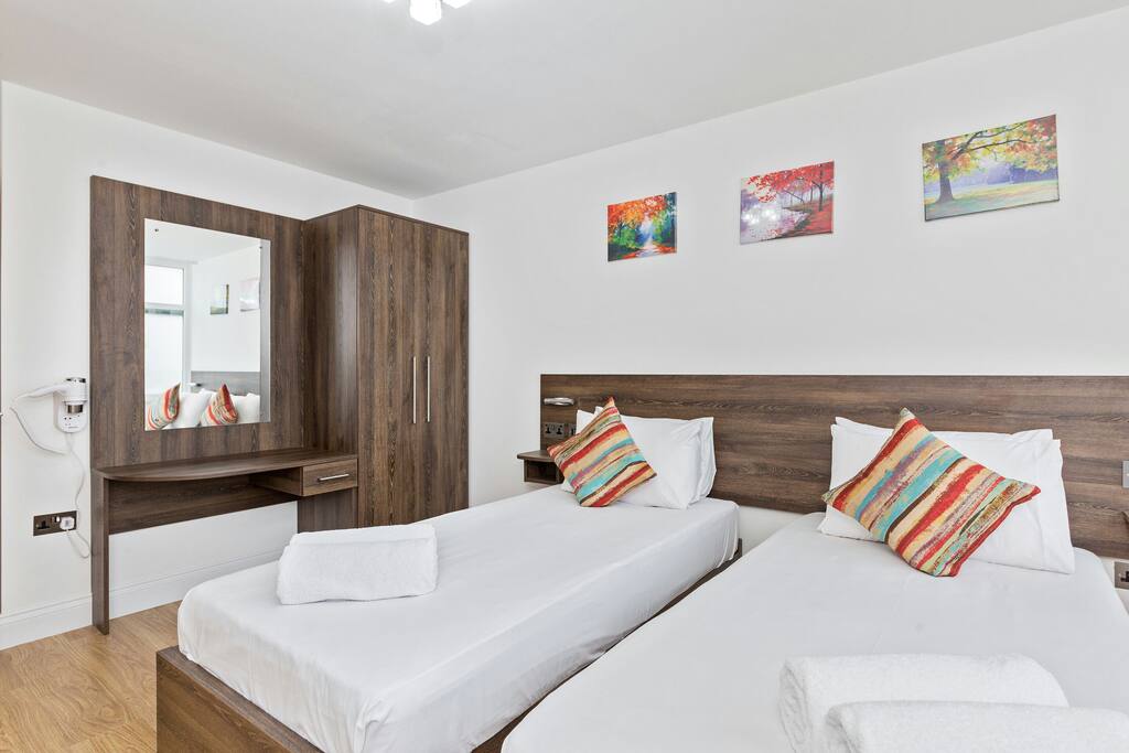 Comfortable twin beds beds made up with hotel-style linen