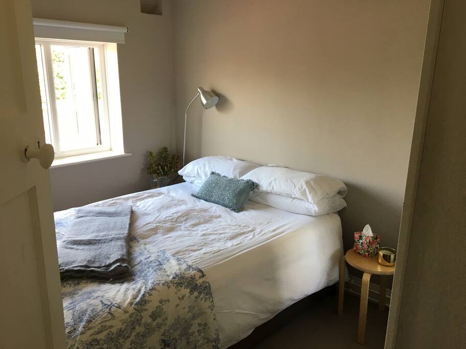 Comfortable double bedroom looking out onto our peaceful garden with clean bedding and towels, large wardrobe with hangers, extra blankets, hairdryer. A real relaxing space.