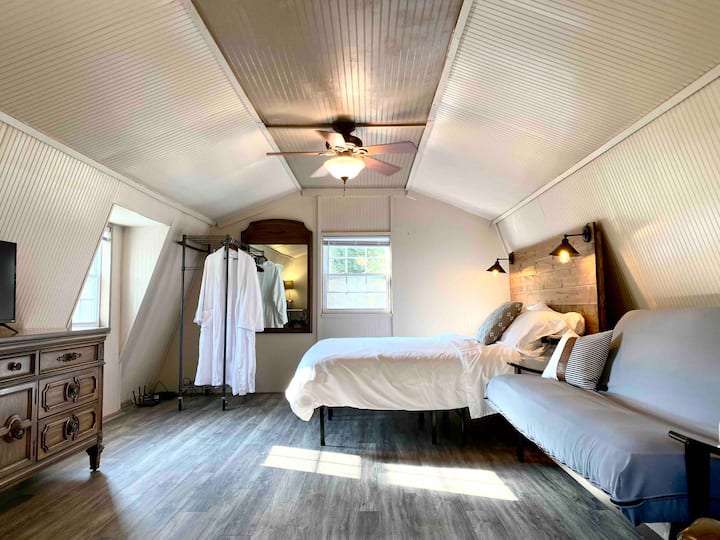Upstairs loft with freshly updated plank flooring: king-sized bed, additional living area and office space