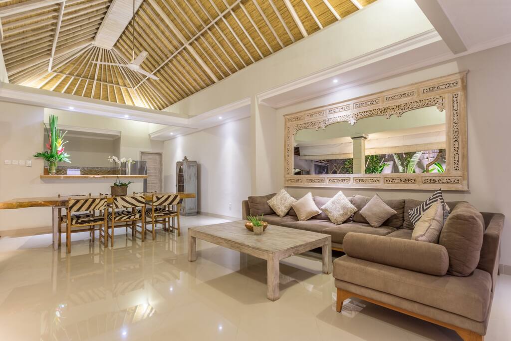 The luxurious open style living, dining and kitchen area overlooks the exquisite pool & lush gardens. The traditional hand woven rattan/bamboo high ceiling and carved Balinese whitewash mirror creates a grand feeling with extra light and airflow.