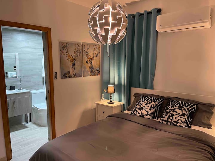 ห้องนอนหลักพร้อมห้องน้ำส่วนตัวและพื้นที่ทำงานสำหรับแล็ปท็อป