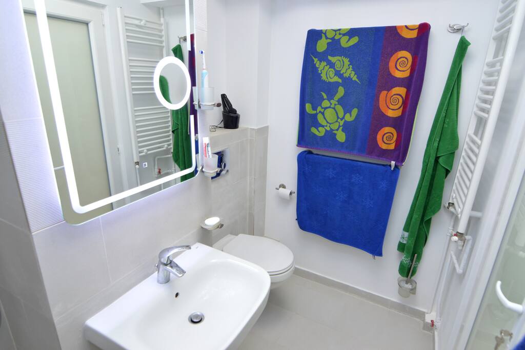 The bathroom. The electric outlet is to the right of the mirror.