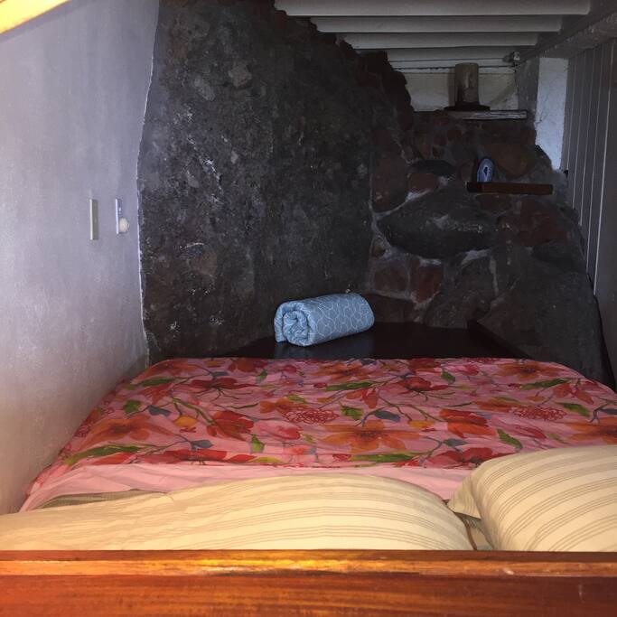 Comfy queen bed (captain's bed custom built into a volcanic wall)