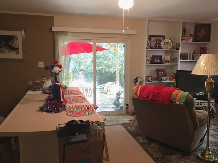 Open kitchen/living space with wooded back yard and deck.