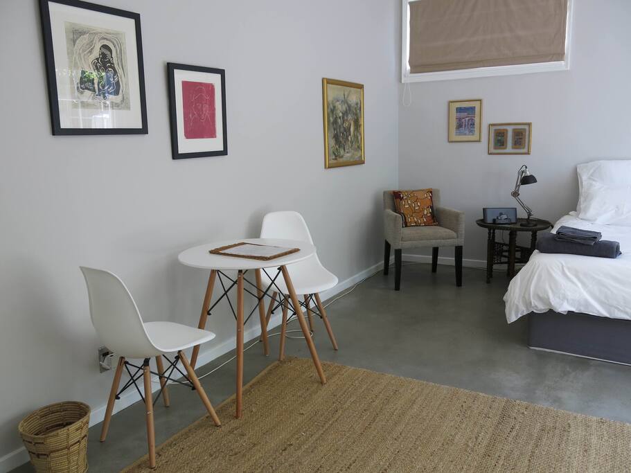 The room has a double bed and a small table and chairs.