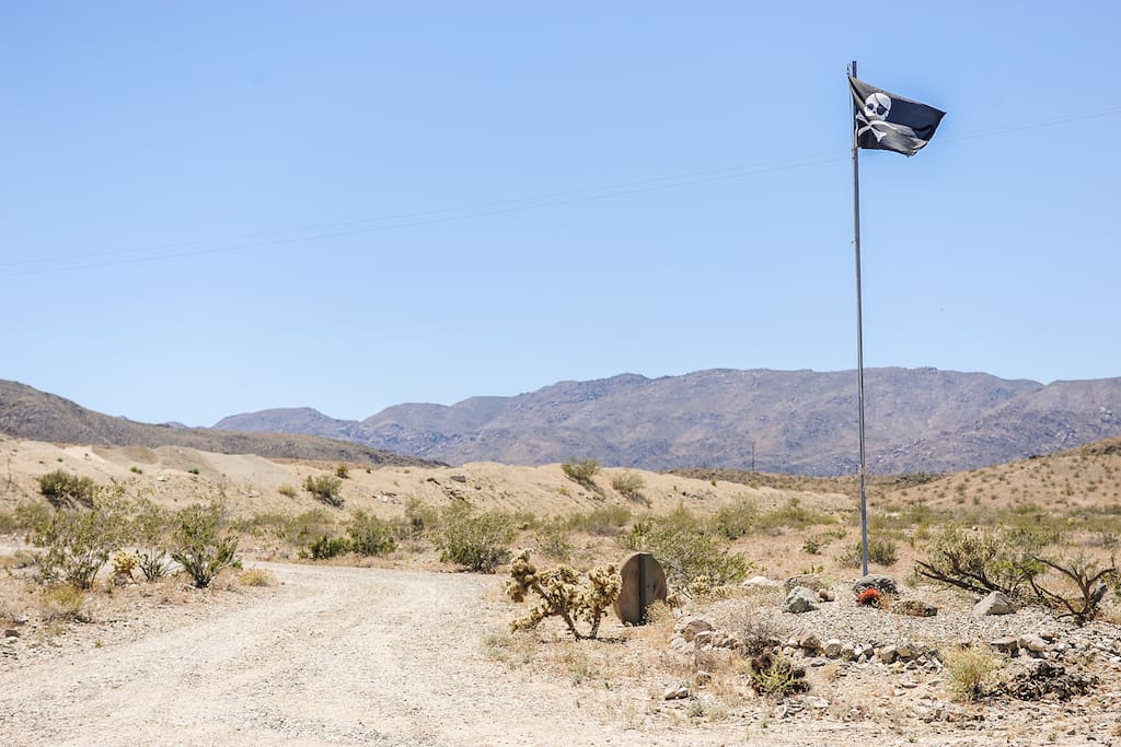 Jolly Roger welcoming committee. View South of the entry/driveway. Joshua Tree National Park, just behind the hills.