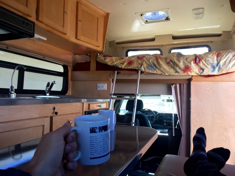 Morning coffee view from the couch. One can see the lofted bed and kitchen area. The couch can also be folded flat for an extra sleeping area.
