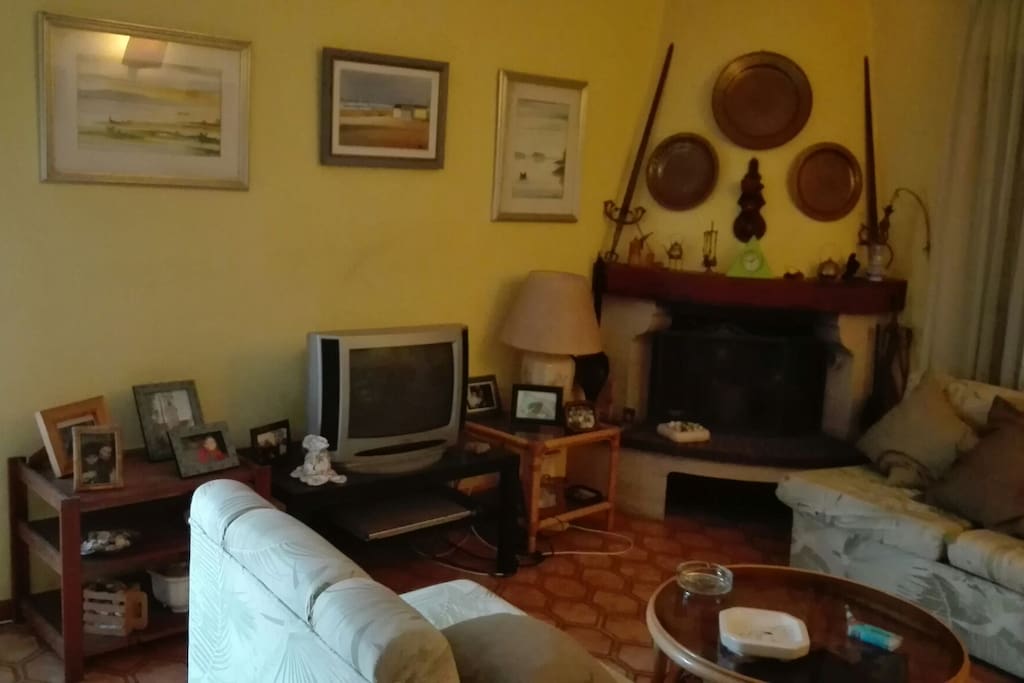Sala de estar com TV, lareira e 3 sofás, sendo 2 sofás- cama, muito confortável