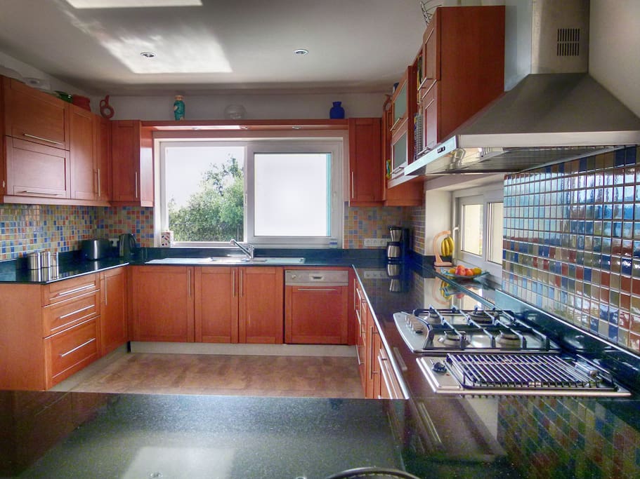 Well-equipped large Kitchen with sliding door to Kitchen Terrace giving onto Pool and Courtyard