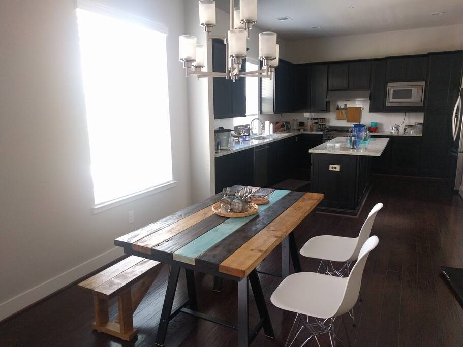 The dining area in the foreground and kitchen in the background. Enjoy your meals with a little bit of the countryside in the modern townhouse.