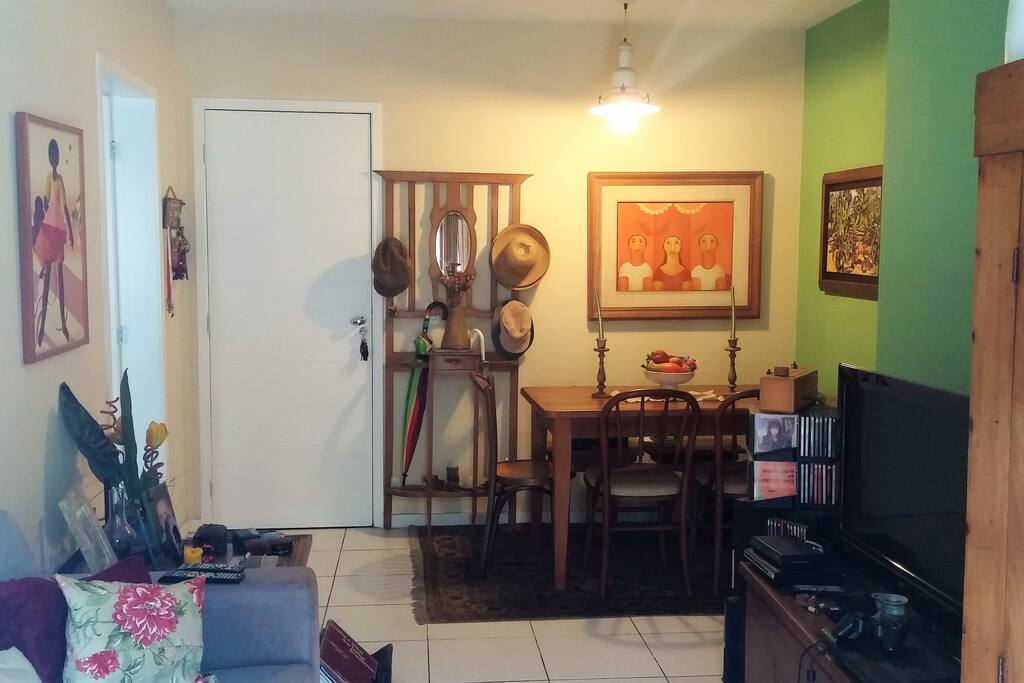 Sala arejada de 2 ambientes com Ar Condicionado, TV, WiFI, sofá e varanda.