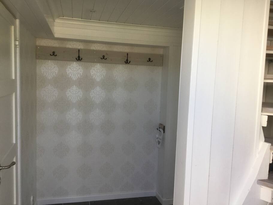 Hall. Entré på bottenvåning, dörr på vänster sida till toalett och tvättstuga med tvättmaskin.