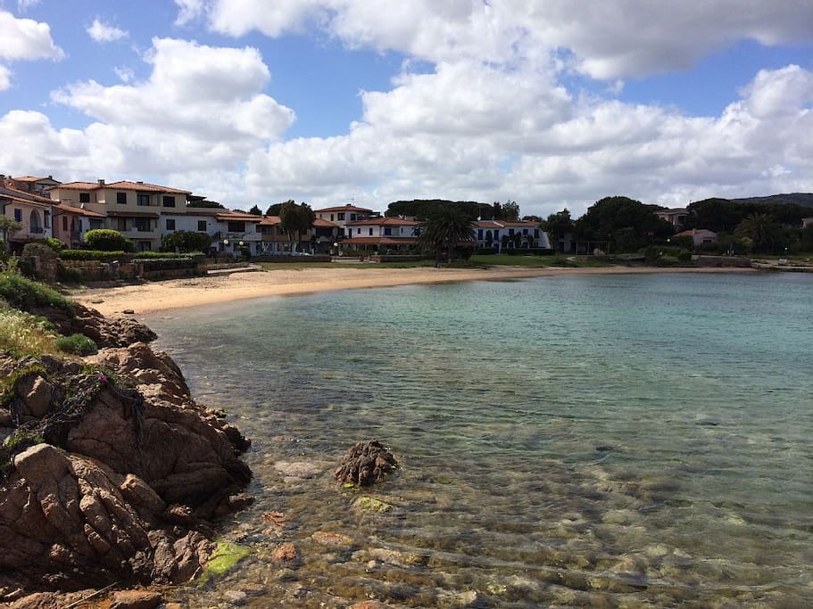 la baia del villaggio vista dagli scogli.. il cancelletto è sulla sinistra. LA baia d'estate è protetta da una linea di boe galleggianti che impedisce alle barche di avvicinarsi,