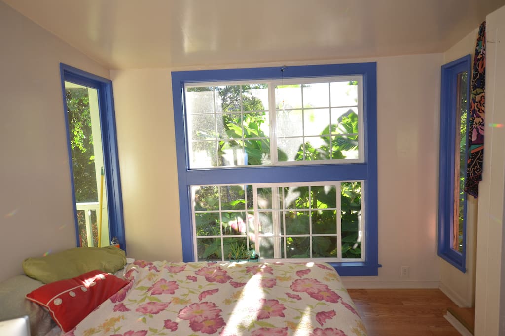 Relaxing, comfy bedroom with lots of light filled windows. No visible neighbors.