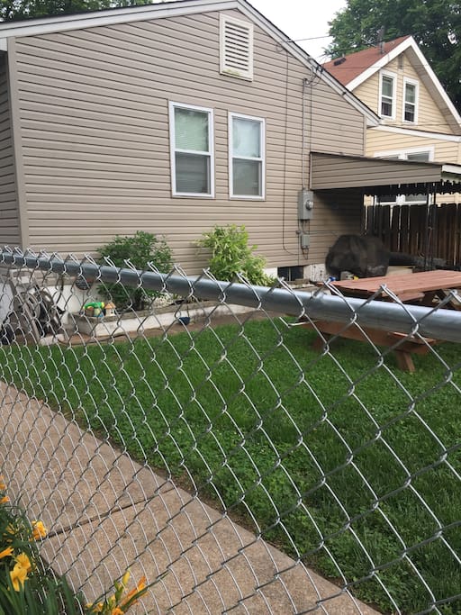 Fenced in backyard with picnic table and propane BBQ grill