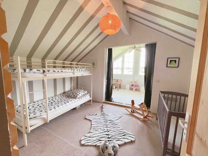 kinderzimmer, 2 Betten im Etagenbett, 1 Babybett. Angrenzendes Spielzimmer mit Panoramablick auf die Landschaft.