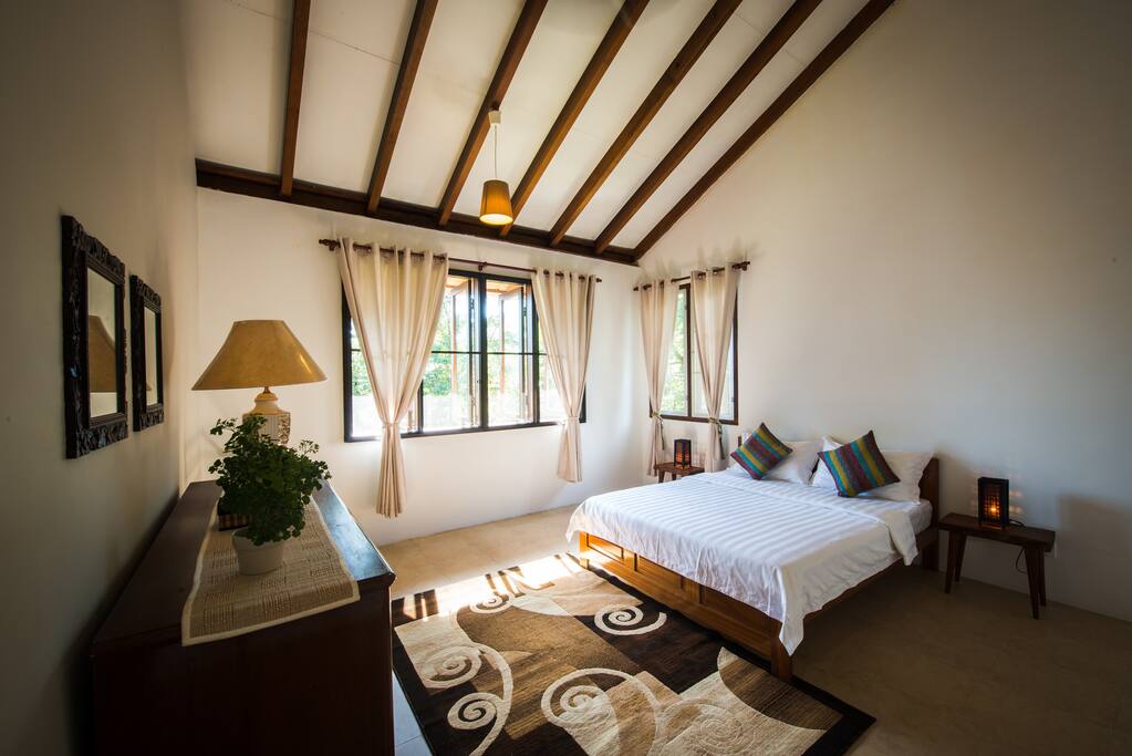 Master Bedroom 1 with a queen-sized bed overlooking the rainforest.