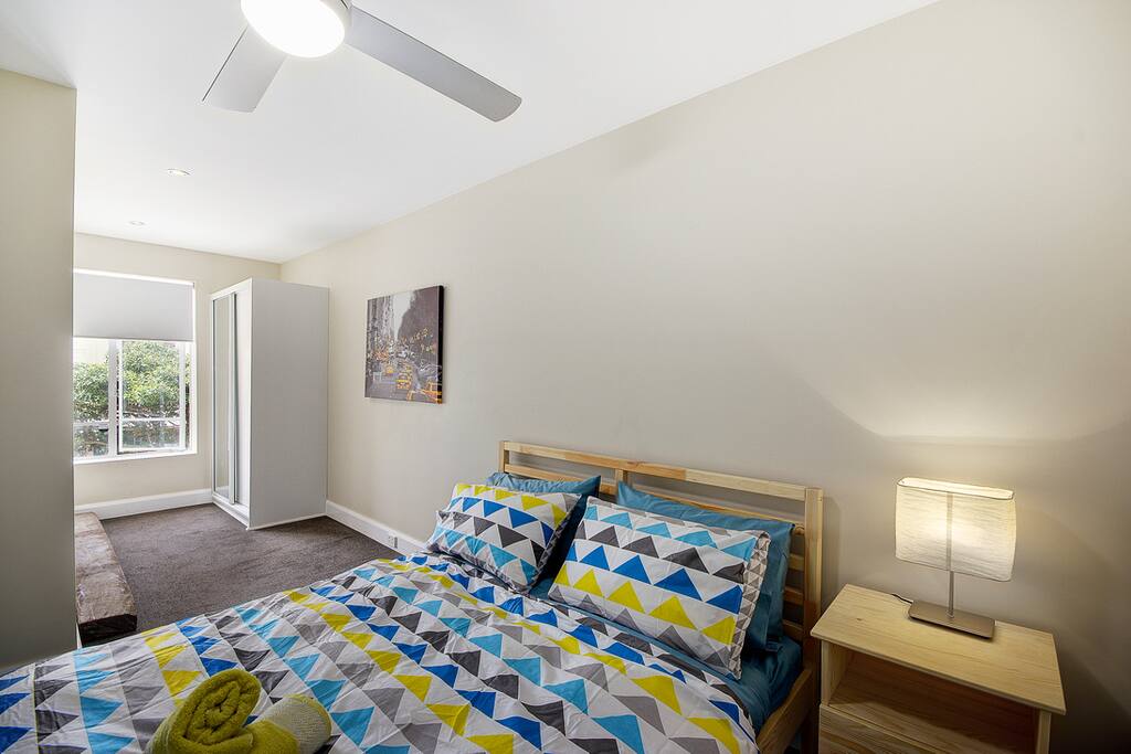The main bedroom has a Queen size bed, large wardrobe with draws and hanging space. the window opens to allow air and closes to cut noise - facing north the view a City Streetscape