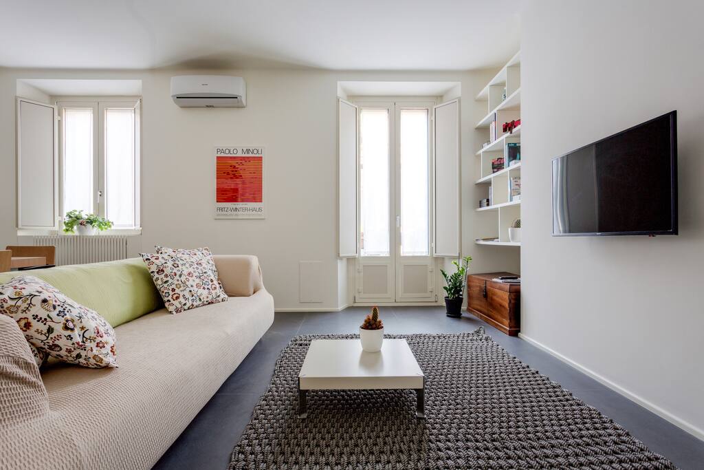 The living room: spacious sofa, TV, AC