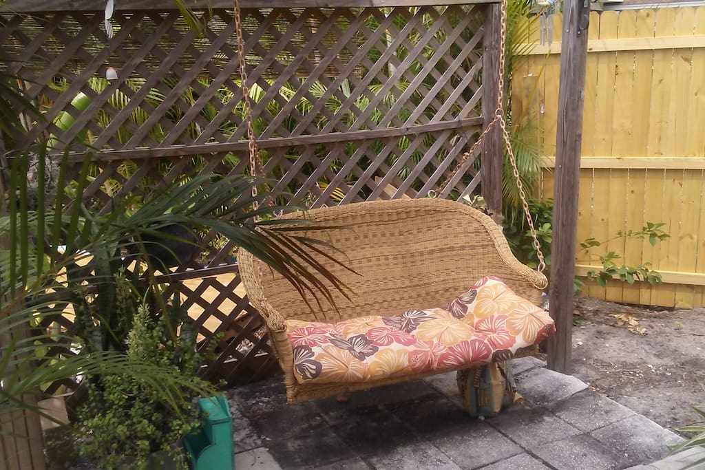a swing love seat by fish pond