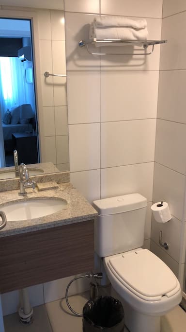 Banheiro com toalhas e papel higiênico