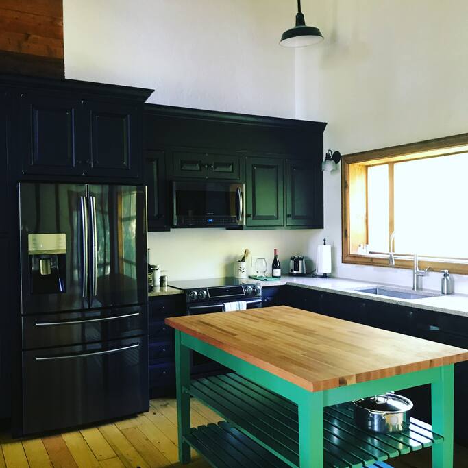 A large open, newly renovated kitchen features new appliances and a John Boos butcher block island. Perfect for cooking with a crowd.
