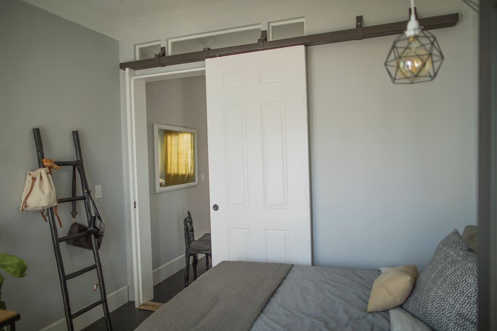 Guest room with barn door opening into shared space