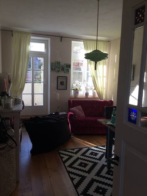 Im Vintage Wohnzimmer trifft Alt auf Moderne und viel Lichteinfall durch die großen Fenster.
