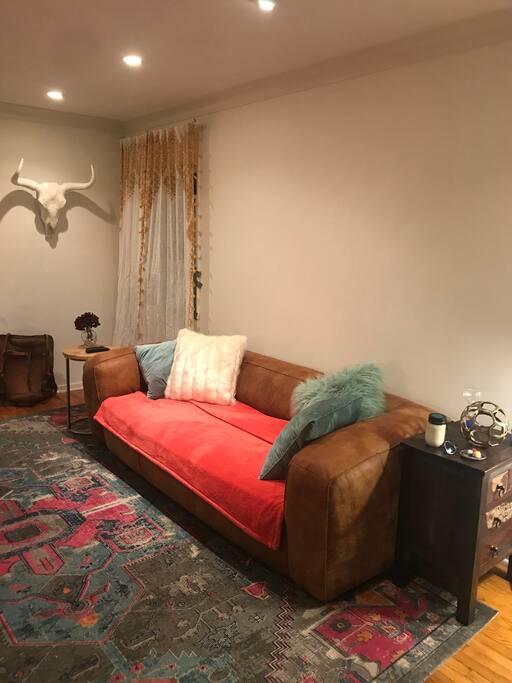 Living room couch + window with A/C unit