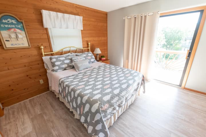 3rd-floor street-facing bedroom with queen size bed. Balcony overlooking the front yard and street view