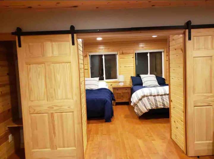 Portes de grange donnant sur la chambre au bord du lac. Avec deux murs de fenêtres pour une vue panoramique sur le lac.