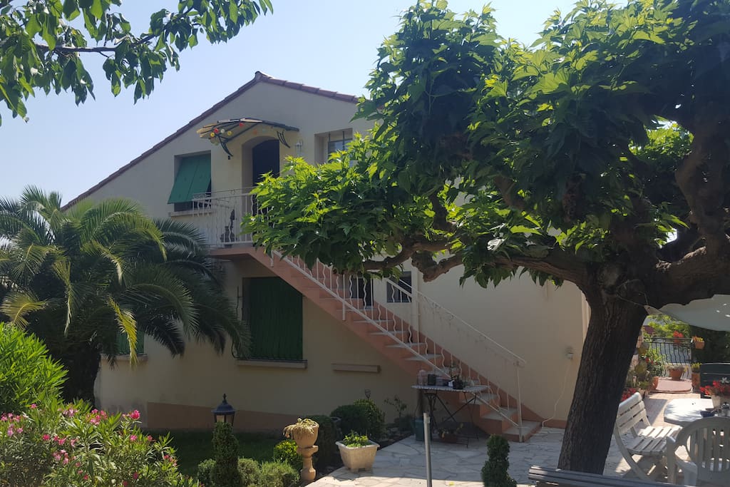 Façade arrière avec escalier extérieur menant aux chambres situées au 1 étage donnant sur jardin avec place de parking
