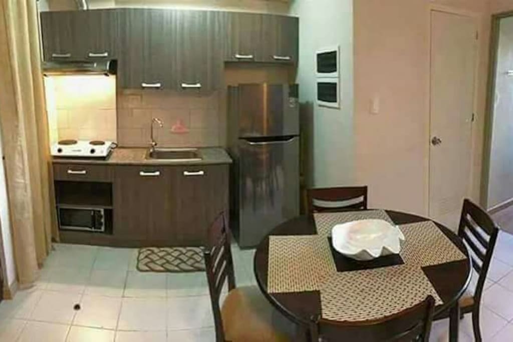kitchen has electric stove, refrigerator, microwave oven, slippers