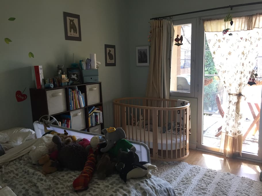 A full bed for adults and a crib for a baby.