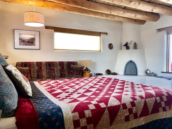 Homey New Mexico elements include viga-and-latilla ceiling, bancos, and adobe construction.