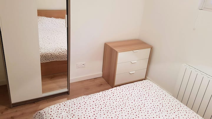 ห้องนอนพร้อมพื้นที่แขวนและตู้ลิ้นชักขนาดเล็ก