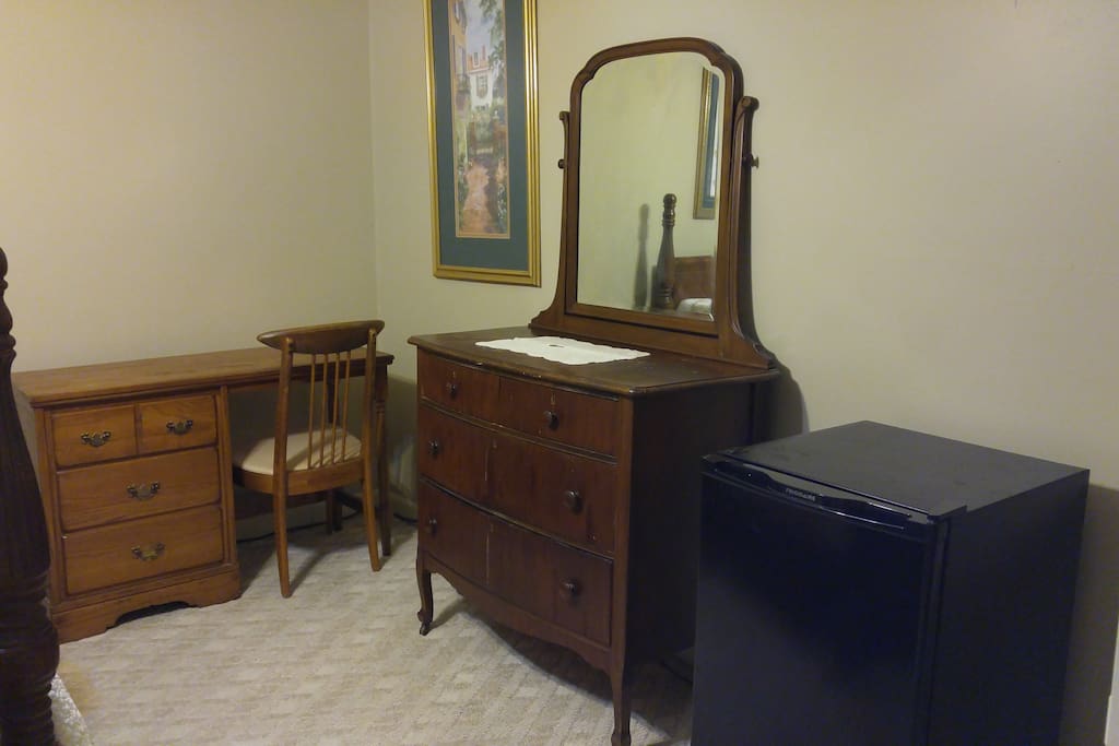 Dresser with mirror, desk and refrigerator.
