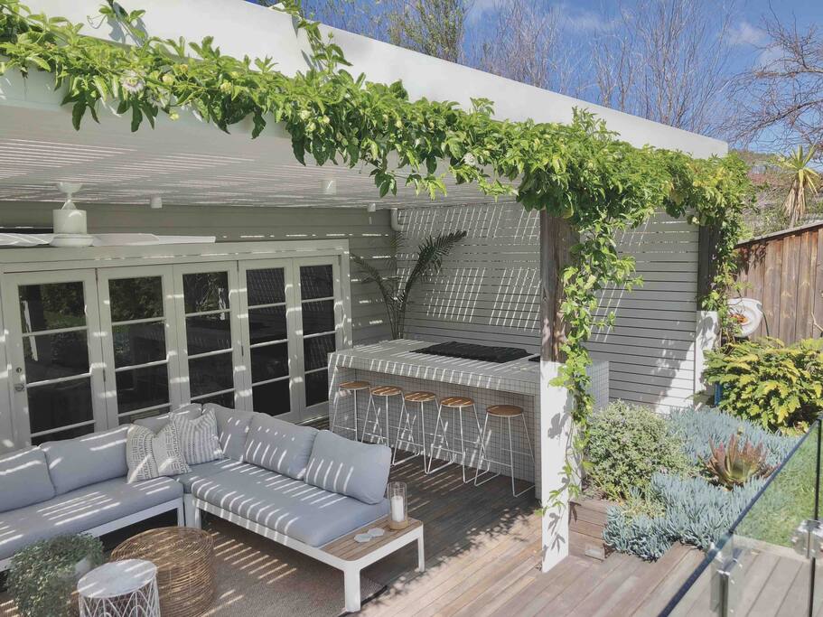 Undercover entertaining area with BBQ/bar overlooking pool and backyard