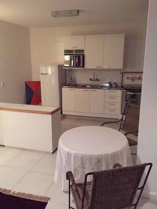 cozinha equipada com fogão, geladeira e micro-ondas